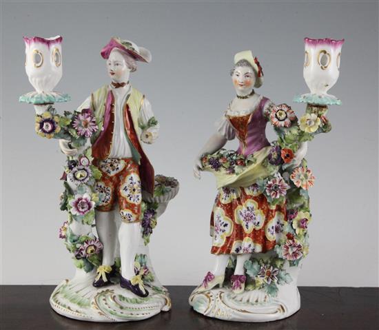 A pair of Derby candlestick figures of a gentleman and a lady, 24cm, damaged